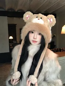 Detailed view of a cute plush bear winter trapper hat with bows and pom-poms on a model