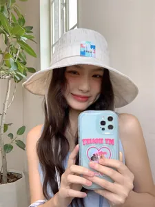 Modella asiatica che indossa un elegante cappello bucket a quadri con sottogola