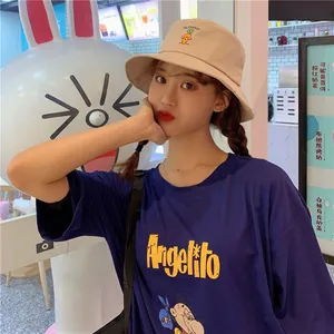 Close-up of beige cotton bucket hat with cute carrot embroidery worn by a model