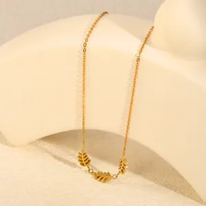 Vista dettagliata dei ciondoli a foglia dorata su una collana a catena minimalista