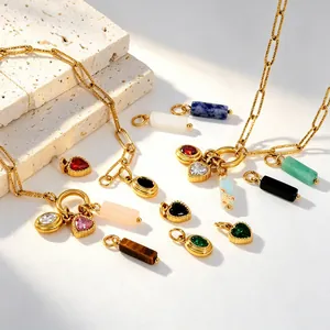 Vue détaillée de pendentifs en pierre naturelle et zircon coeur sur chaînes dorées.