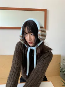 Plush striped earmuffs for winter cold protection, detail view on model.