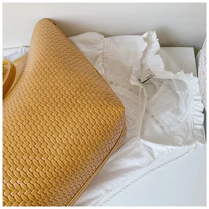 Close-up detail of the intricate woven pattern on a tan summer tote bag