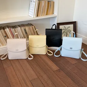 Four colors of minimalist women's backpacks in a lifestyle indoor setting