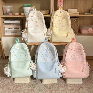 Five pastel cartoon backpacks with pony prints and plush charms in a lifestyle setting