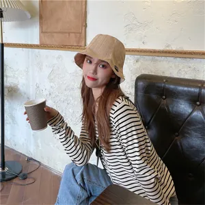 Asian woman wearing a khaki pleated bucket hat in a cafe for stylish sun protection