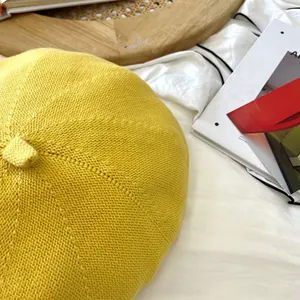 Macro view of vibrant yellow knitted beret hat showing soft breathable fabric texture