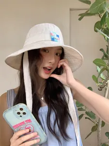 Elegante cappello alla pescatora bianco a scacchi con laccetti indossato da modella