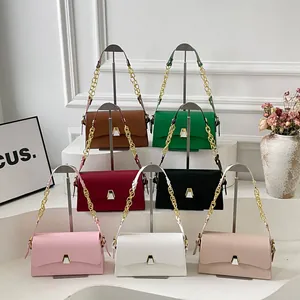 Detail view of stylish square handbags in multiple colors with gold chain straps.