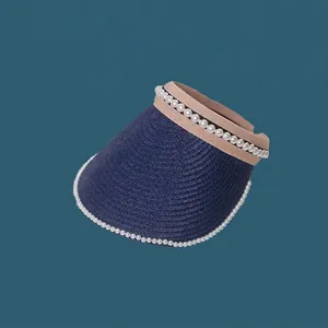 Detailed view of navy blue straw sun visor hat with elegant pearl decorations