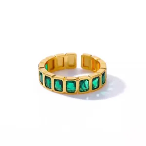 Close-up of vintage gold adjustable open ring with emerald-cut green cubic zirconia stones