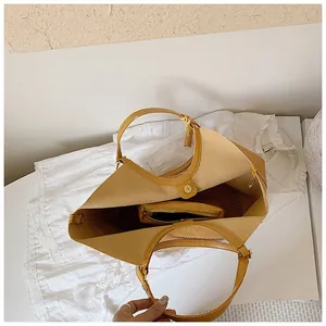 Interior detail view of a large capacity woven straw tote bag featuring an inner pouch
