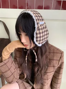 Detail view of retro plaid plush earmuffs with lace-up design for winter warmth