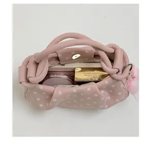 Detailed top view of a pink polka dot handbag showing its spacious interior capacity