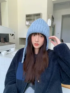 Asiatisches Model mit einer blauen Strickmütze im koreanischen Stil für den Winterwärme.