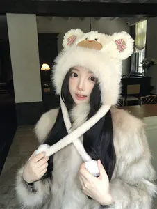 Close-up detail of a cute white plush bear trapper hat with pink bows for winter warmth.