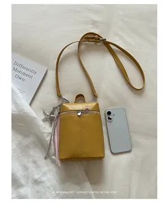 Vista dall'alto della borsa gialla minimalista per cellulare con smartphone per scala di grandezza