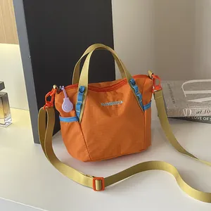 Orange grid nylon crossbody bag with adjustable yellow strap and blue accents