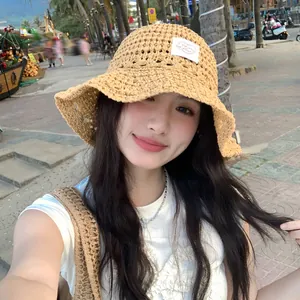 Sombrero de pescador de paja tejida calada para mujer en un entorno de playa de verano
