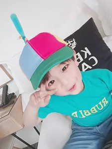 Detail view of a kid wearing a colorful patchwork baseball cap with spinning propeller