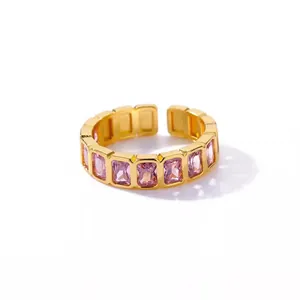 Close-up detail of an elegant gold open ring featuring rectangular pink zircon stones