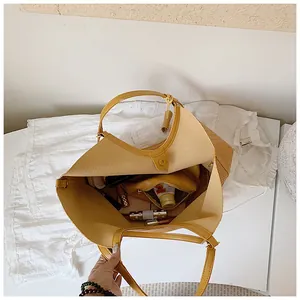 Internal view of a large yellow woven tote bag showing storage capacity with cosmetics