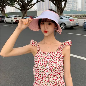 Gros plan d'un mannequin portant un chapeau de soleil réversible rose et blanc