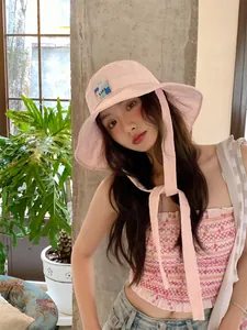 Primo piano dettagliato di un elegante cappello da pescatore rosa con lunghi lacci