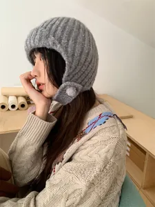 Nahaufnahme einer Frau mit einer grauen Strickmütze mit gemütlichen Ohrenklappen