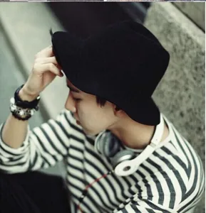 Side view of a stylish black wool felt cloche hat worn by a model in outdoor setting