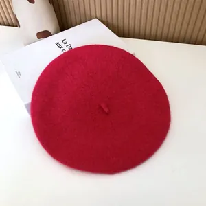 Close-up detail of a vibrant red wool beret hat showing soft texture