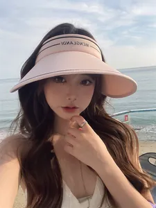 Mannequin asiatique à la plage avec une visière rose, vue détaillée de l'article