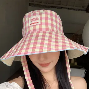 Pink and yellow checkered wide brim bucket hat with adjustable straps for summer