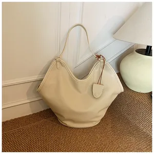 Detailed view of a cream white large capacity slouchy tote bag placed on a woven mat