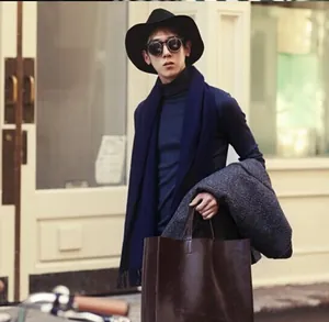 Close-up view of a stylish black wool felt cloche hat worn by a model in a winter street setting