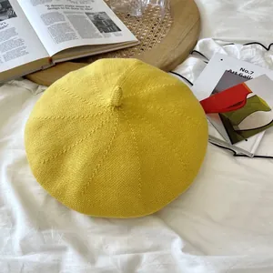Detailed macro view of a breathable yellow knitted beret hat in a cozy lifestyle setting