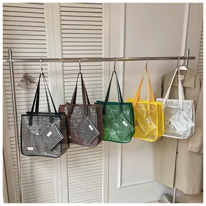 Detailed display of multiple colored grid tote bags with matching small pouches.