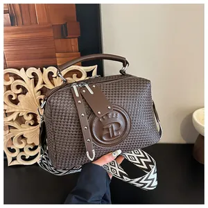 Detailansicht der braunen gewebten Handtasche mit Kronenlogo und geometrischem Gurt