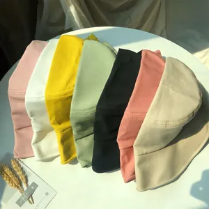 Detailed close-up showing a variety of colorful cotton bucket hats for women on a table