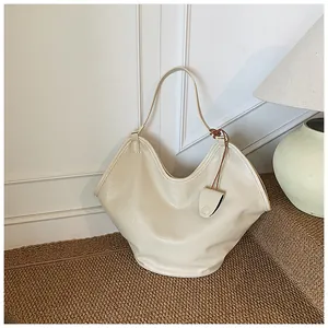 Large cream-colored slouchy tote bag displayed on a textured step in a chic interior