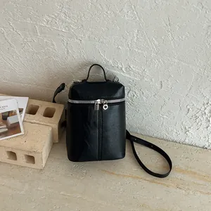 Dettaglio borsa a tracolla nera minimalista a forma di scatola con accenti argentati