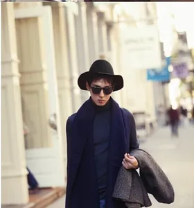 Elegant black wool cloche hat for women worn in a stylish urban street setting