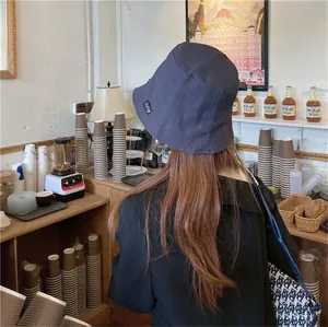 A lifestyle back view showing the texture of a navy pleated fisherman bucket hat