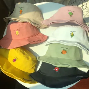Close-up of various colors of bucket hats with cute cartoon vegetable embroidery designs
