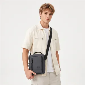 Modern grey small square crossbody bag shown on a male model for casual styling