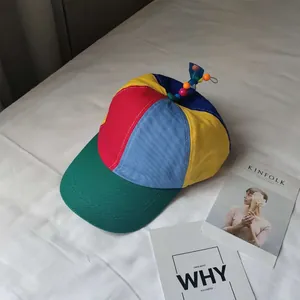 Detailed view of a colorful patchwork kids baseball cap with a cute propeller topper.