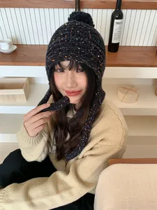 Stylish winter knit trapper hat featuring colorful candy flecks and soft pom-pom