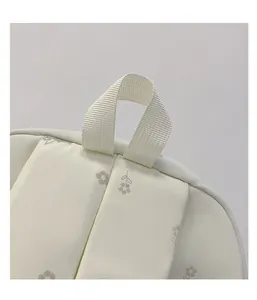 Detail of floral backpack top handle and padded shoulder straps