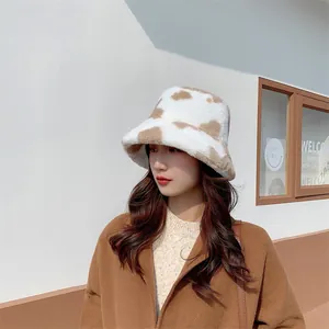 Close-up of a stylish cow print plush bucket hat worn by a model in winter weather