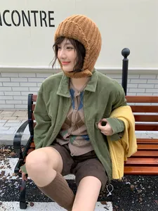 Nahaufnahme einer braunen Strickmütze mit Ohrenschutz für winterliche Wärme